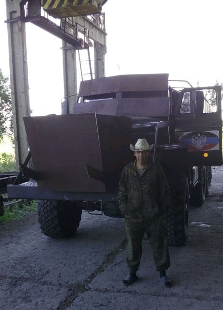 Российский солдат Эжен Ередеев на фоне транспорта "ДНР"