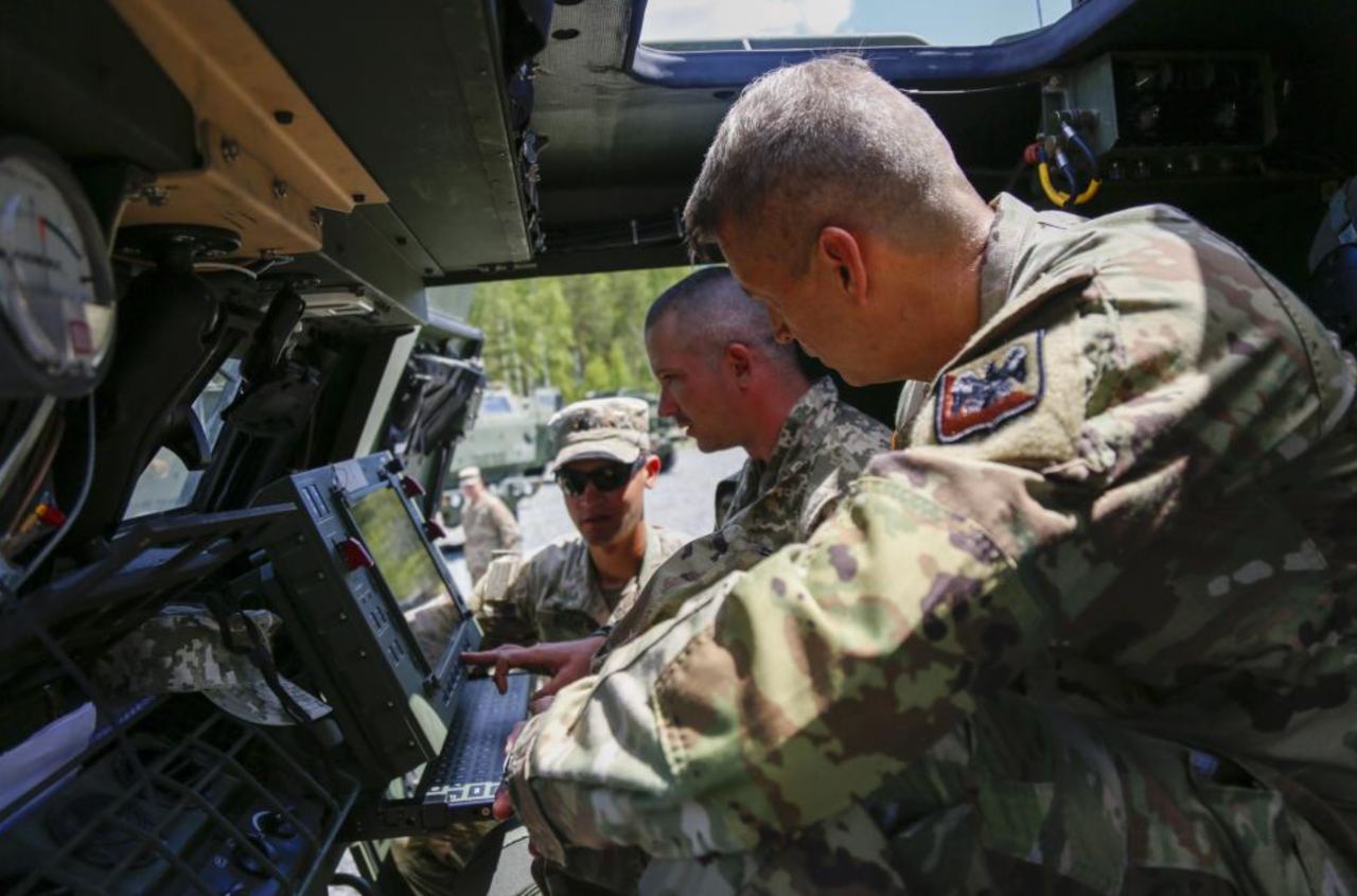 Командувач Нацгвардії США 4-зірковий генерал Деніел Хокансон спілкується з українським військовим в кабіні M142 HIMARS у навчальному центрі Графенвер, Німеччина