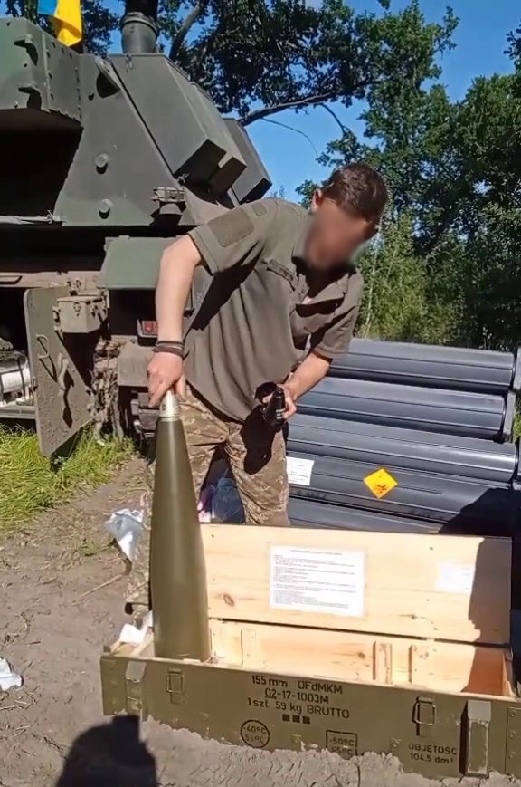 Український військовий дістає словацький 155-мм боєприпас “OFd MKM” для САУ “KRAB”. Липень 2022. Україна. Фото: Ukraine Weapons Tracker