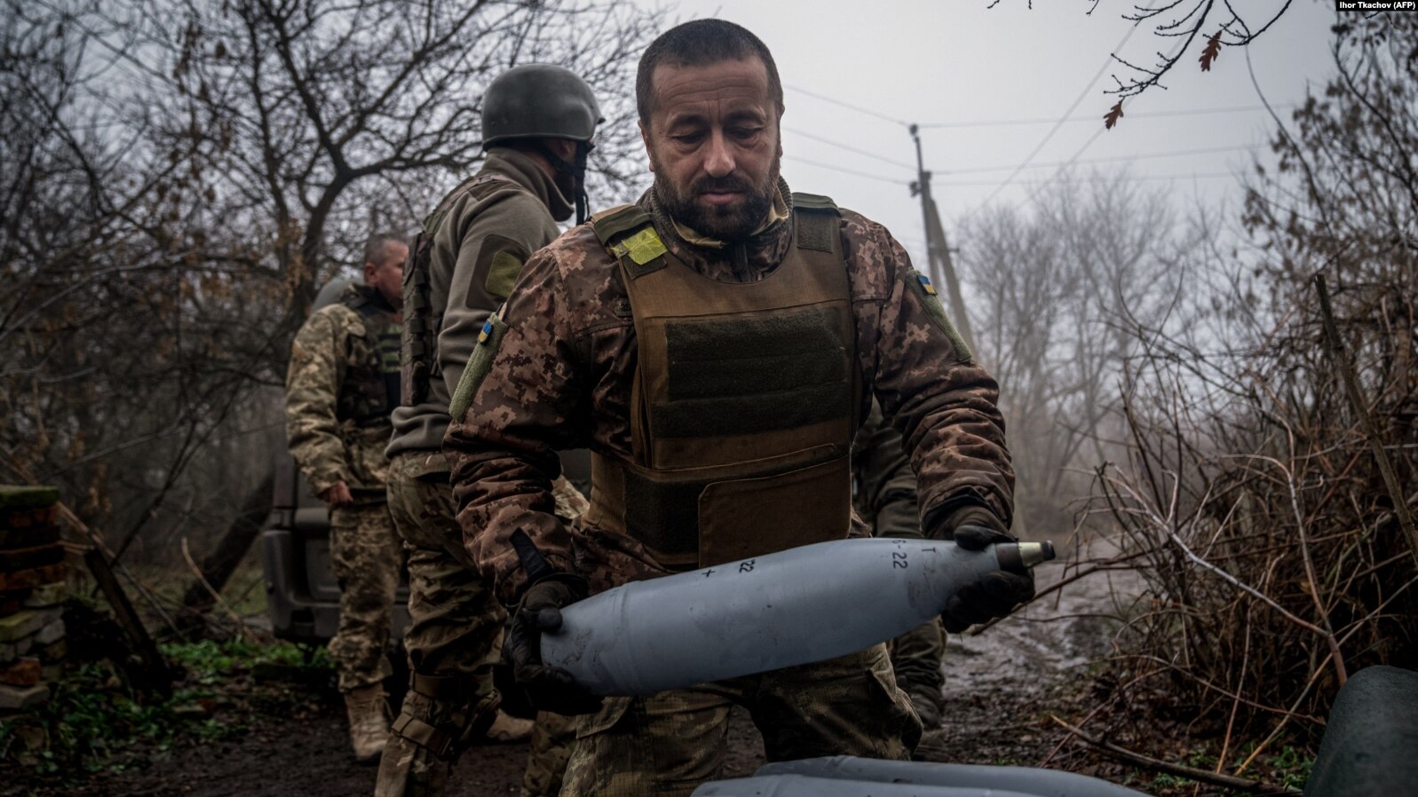 Український артилерист несе 122-мм снаряд для самохідної гаубиці 2С1 "Гвоздика" на позиції вздовж лінії фронту поблизу Бахмута 10 грудня 2022 року. Фото: "Радіо "Свобода".